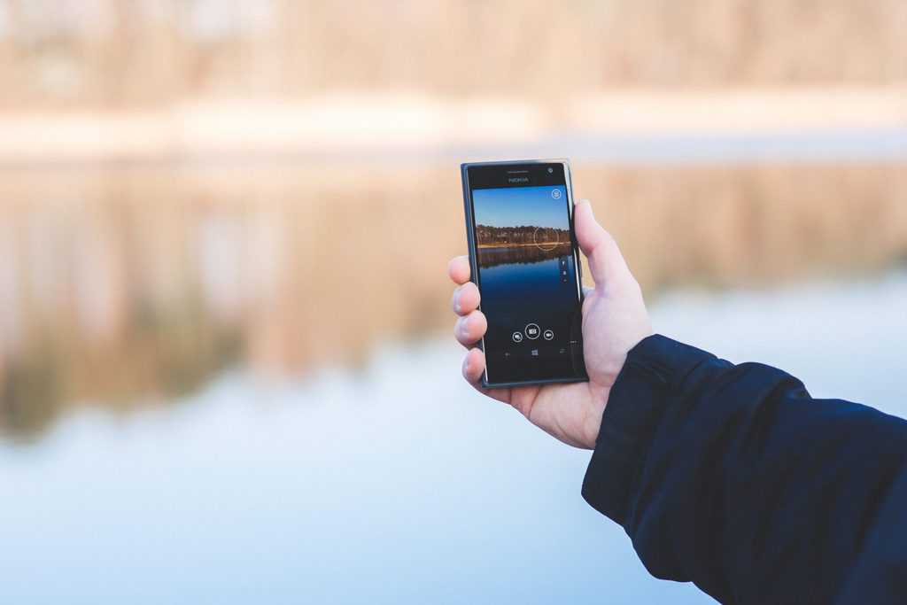 man hand smartphone lake scaled