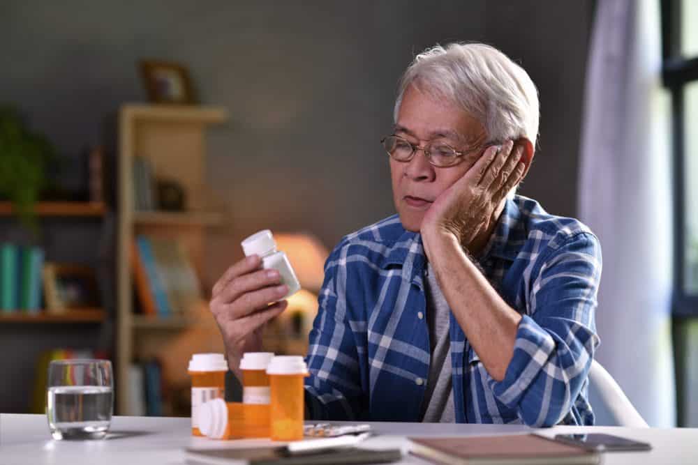 Asian older man with medicine bottles e